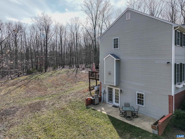 view of property exterior featuring a yard, a patio, and french doors