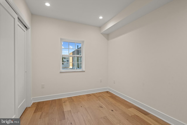 unfurnished bedroom featuring light wood-type flooring and a closet