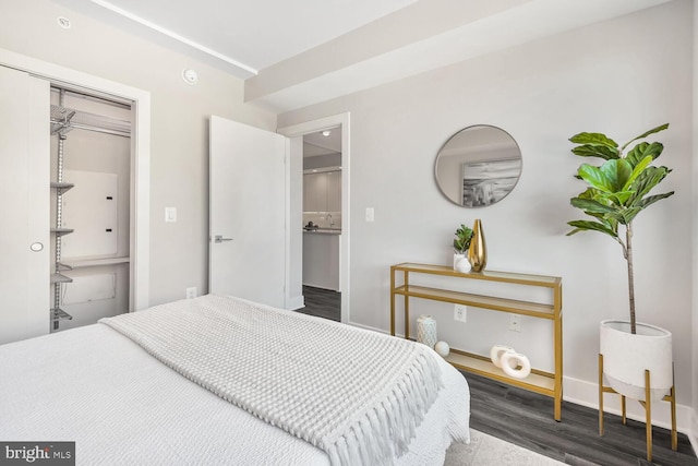 bedroom featuring wood finished floors, a closet, and baseboards