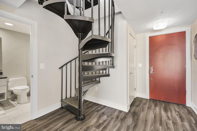 foyer with stairway, baseboards, and wood finished floors