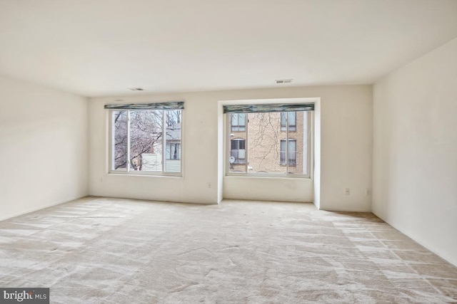 unfurnished room with visible vents and carpet flooring