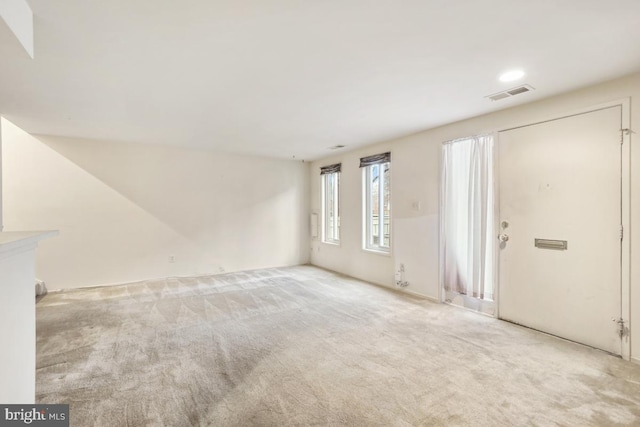 unfurnished living room with carpet flooring and visible vents