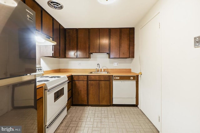 kitchen featuring white appliances, visible vents, a sink, light countertops, and under cabinet range hood