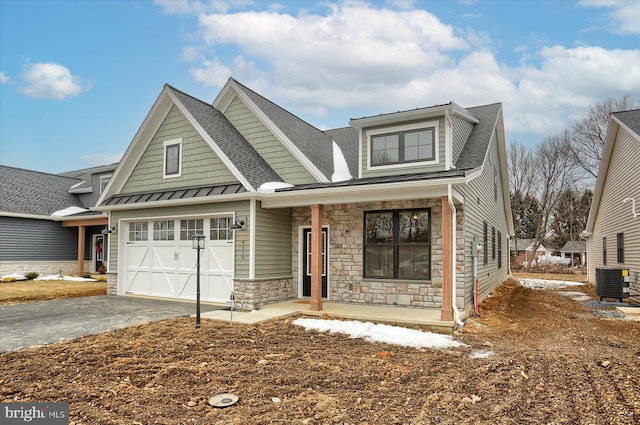 view of front of house featuring central AC, a garage, and covered porch