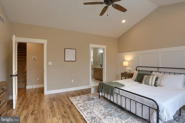 bedroom with vaulted ceiling, ensuite bathroom, ceiling fan, and light wood-type flooring