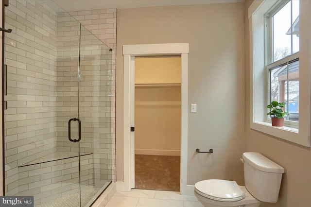 bathroom featuring tile patterned floors, a wealth of natural light, a shower with door, and toilet