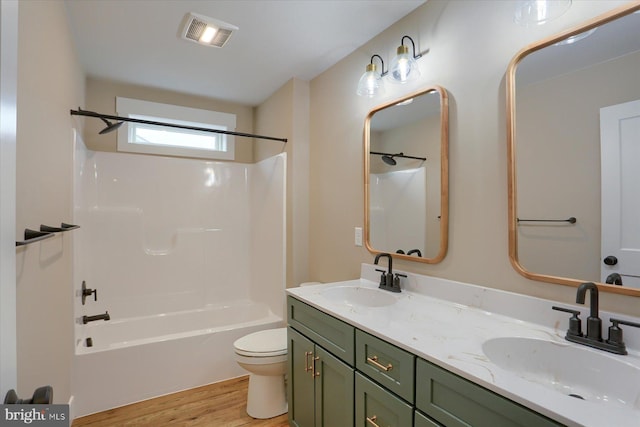 full bathroom featuring hardwood / wood-style flooring,  shower combination, toilet, and vanity