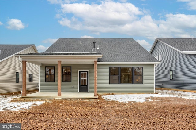 rear view of property featuring covered porch