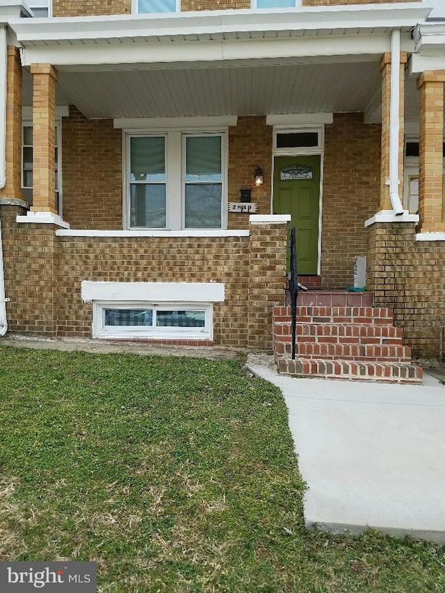 view of exterior entry featuring covered porch