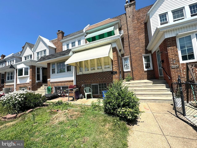 view of front of property with central AC and a front yard