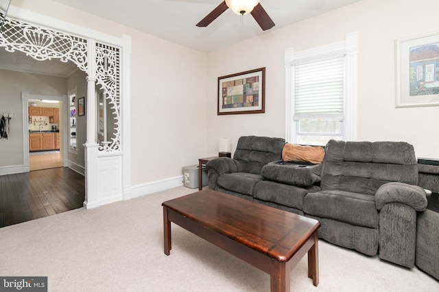 carpeted living room with ceiling fan