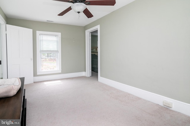 unfurnished room featuring ceiling fan and light carpet