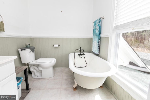 bathroom with a washtub, tile patterned floors, and toilet