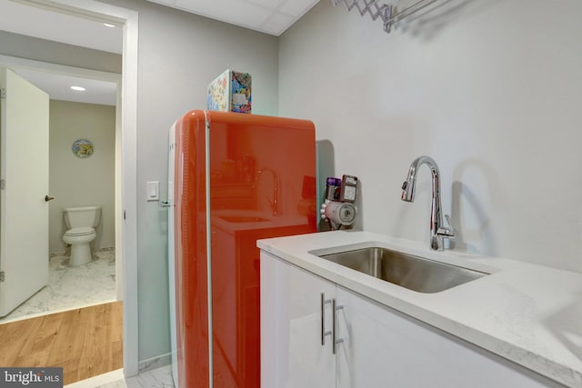 laundry room featuring marble finish floor and a sink