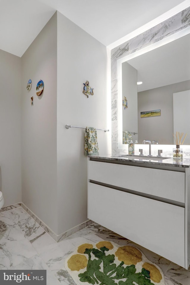 bathroom featuring marble finish floor, baseboards, and vanity