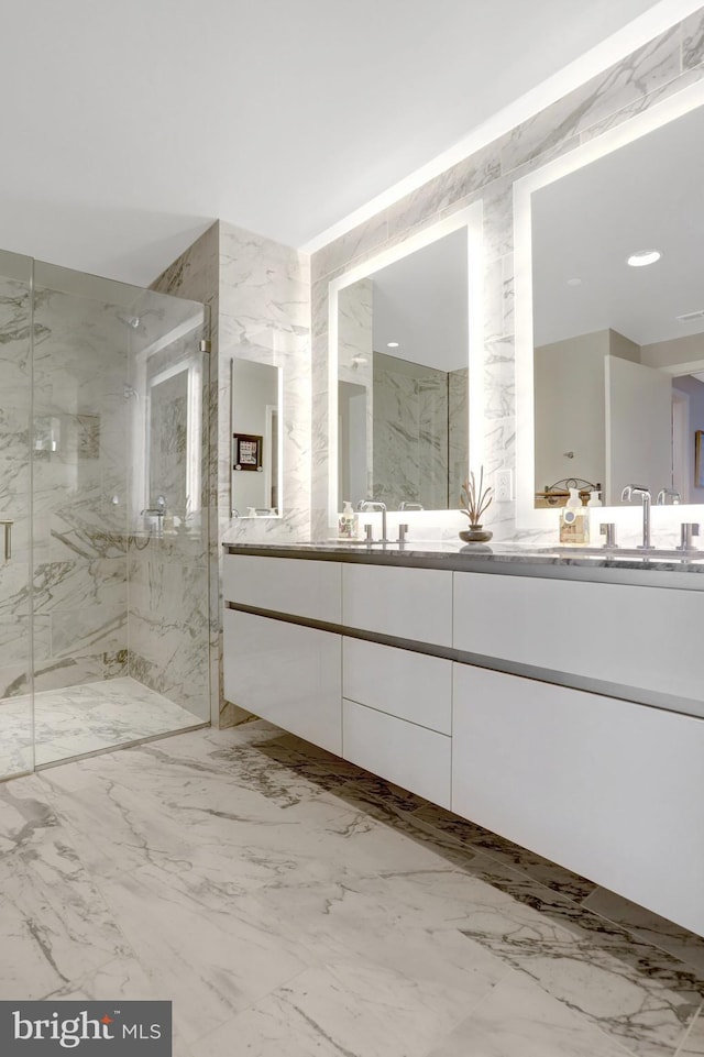 full bathroom featuring marble finish floor, a sink, a marble finish shower, and double vanity