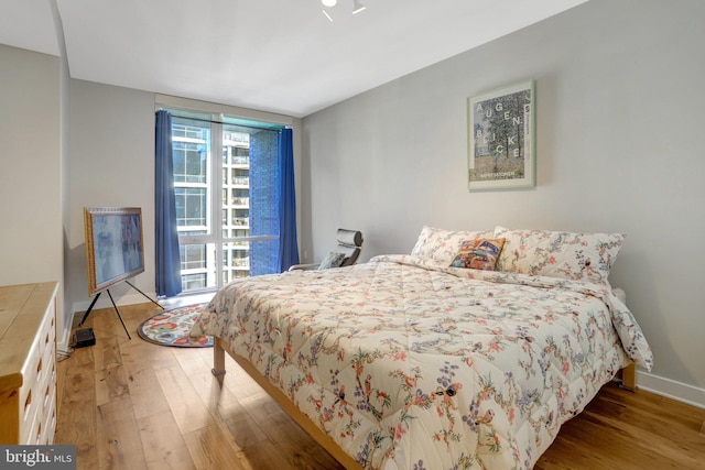 bedroom featuring baseboards and light wood finished floors