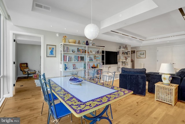 dining area featuring a tray ceiling, visible vents, light wood-style flooring, and recessed lighting