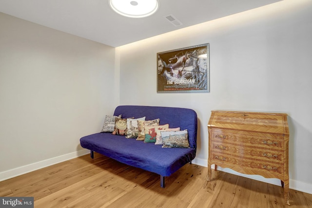 sitting room featuring wood finished floors, visible vents, and baseboards