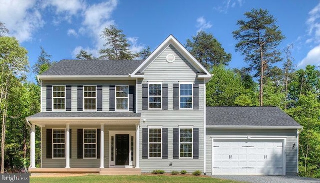 view of front of home with a garage, a front yard, covered porch, and gravel driveway