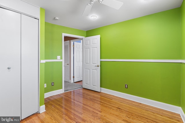 unfurnished bedroom featuring light wood-type flooring, a closet, and ceiling fan