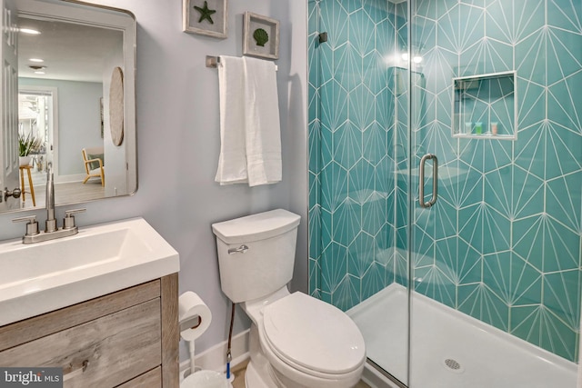 bathroom with vanity, toilet, and an enclosed shower