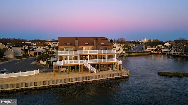 back house at dusk featuring a water view