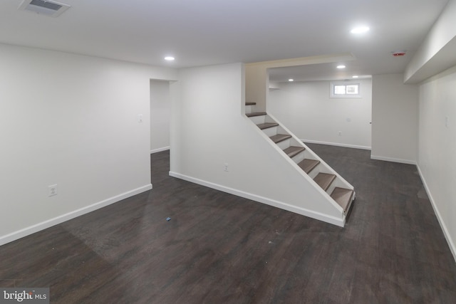 basement with dark hardwood / wood-style flooring