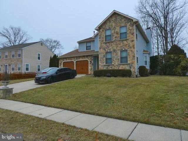 view of front of property featuring a front lawn and a garage