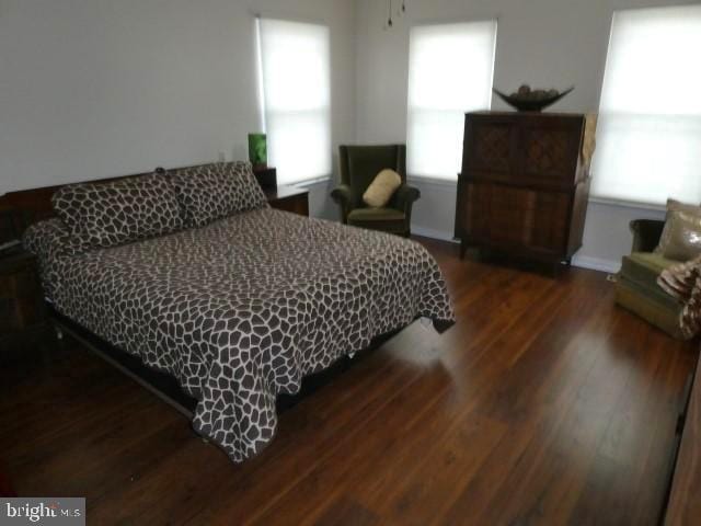 bedroom with dark hardwood / wood-style flooring