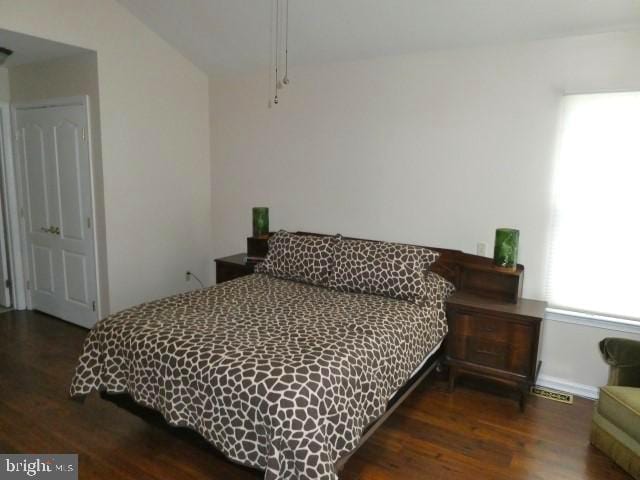 bedroom with dark wood-type flooring