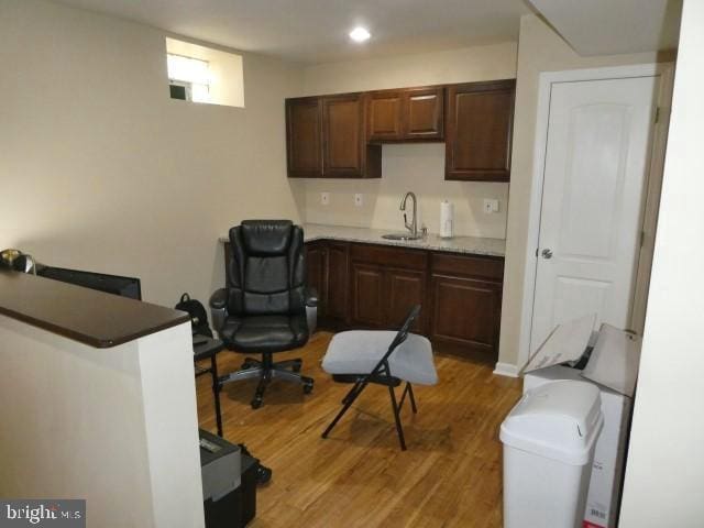 kitchen with wood-type flooring, dark brown cabinetry, and sink