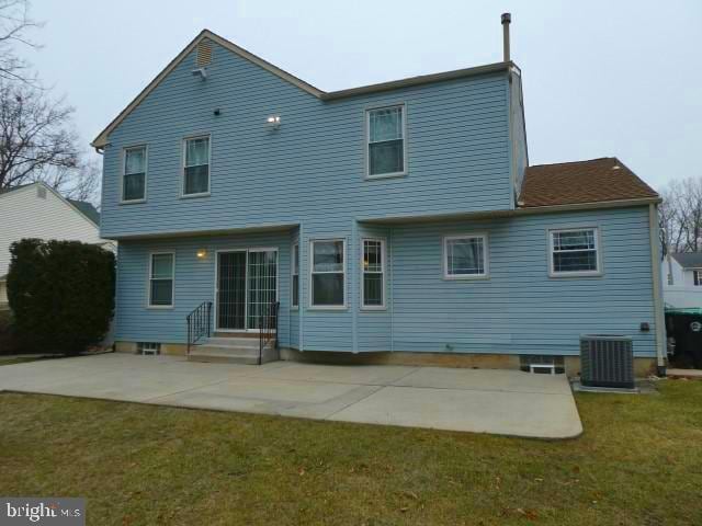 back of property featuring central AC, a patio, and a lawn