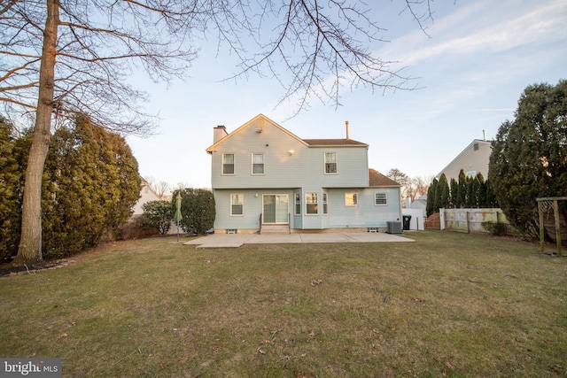 rear view of property with central AC, a patio, and a yard