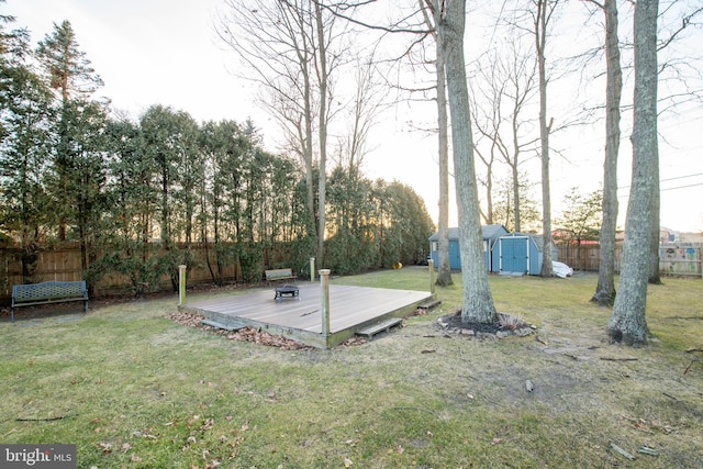 view of yard featuring a wooden deck and a storage shed