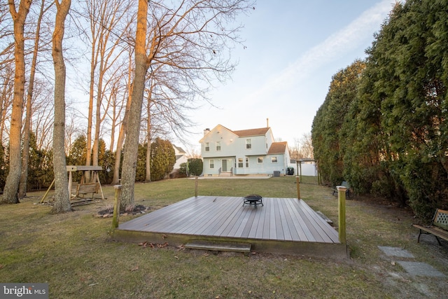 view of yard featuring an outdoor fire pit, a deck, and a playground