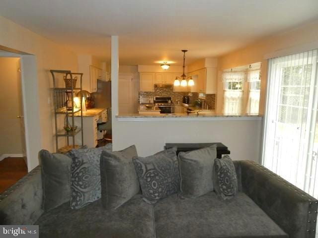 living room featuring a chandelier and a healthy amount of sunlight