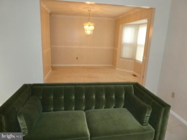 interior space featuring carpet floors, crown molding, and a chandelier