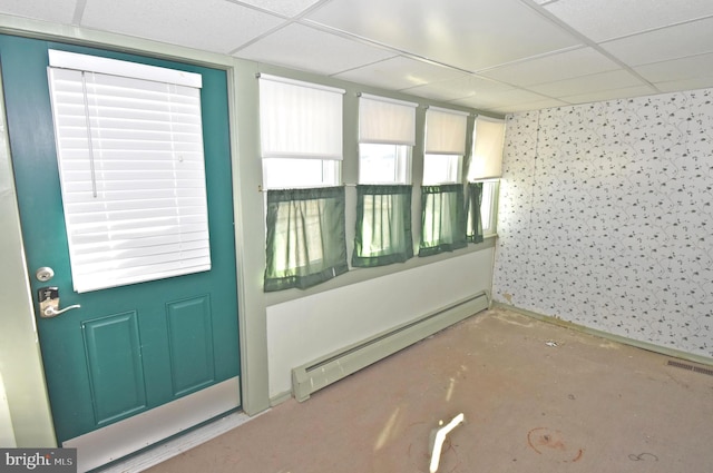 interior space with a paneled ceiling, visible vents, and baseboard heating