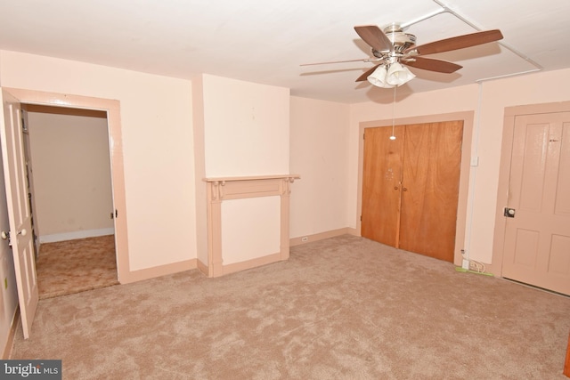 empty room with light colored carpet, ceiling fan, and baseboards