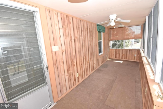 unfurnished sunroom with ceiling fan