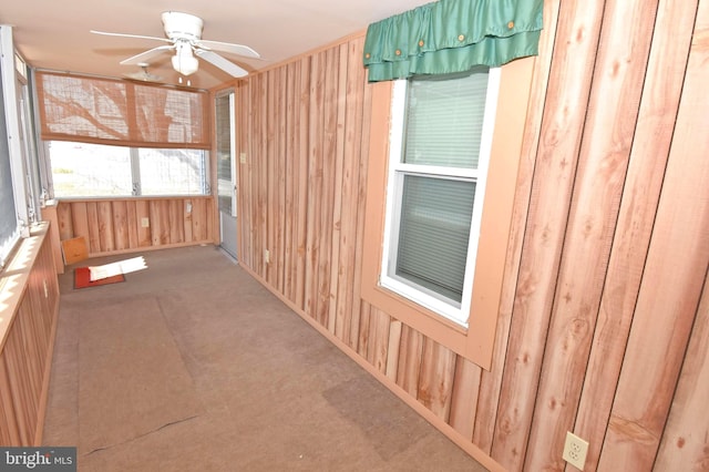 unfurnished sunroom featuring ceiling fan