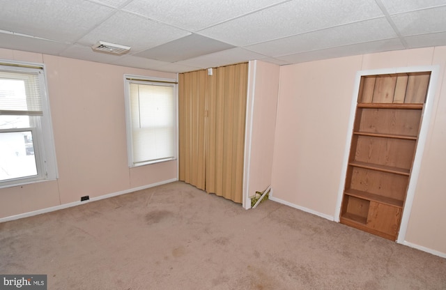 unfurnished room with light carpet, a drop ceiling, and visible vents