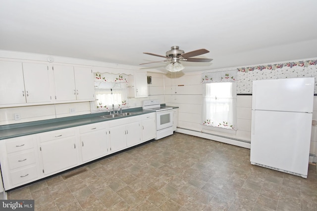 kitchen featuring dark countertops, a baseboard radiator, white cabinetry, white appliances, and plenty of natural light