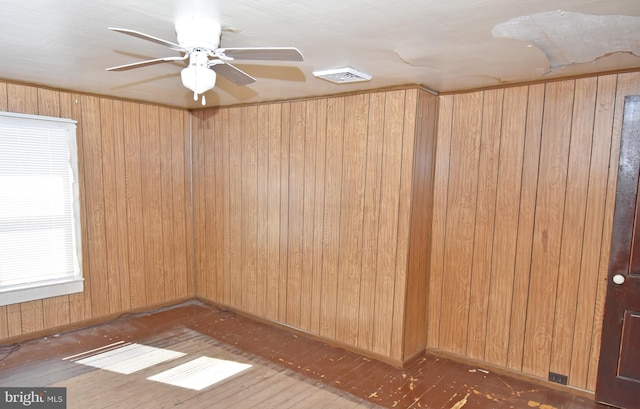 spare room featuring baseboards, dark wood finished floors, visible vents, and a ceiling fan