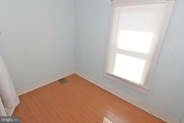 unfurnished room with hardwood / wood-style flooring and baseboards