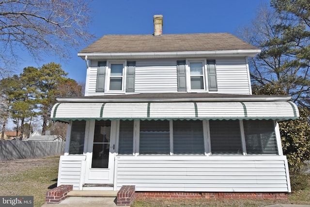 view of front of property featuring a chimney and fence