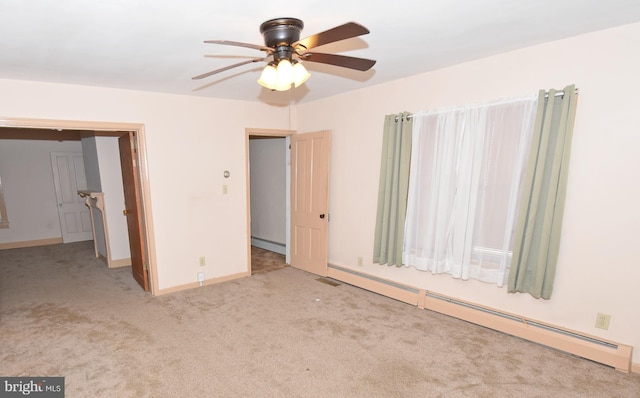 unfurnished bedroom featuring light colored carpet, a baseboard heating unit, a ceiling fan, baseboards, and baseboard heating