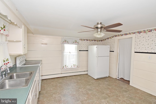 kitchen featuring white appliances, white cabinetry, a sink, and baseboard heating