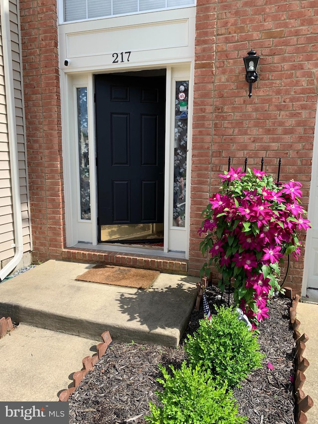 doorway to property with brick siding